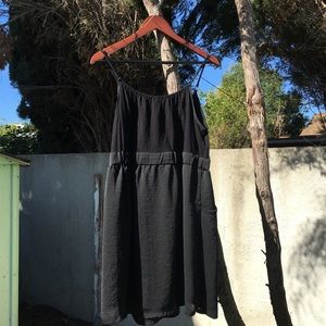 Black wavy dress with side pockets .